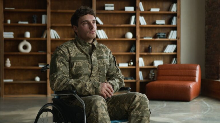 Sad pensive depressed young Caucasian male military officer veteran warrior man with disability